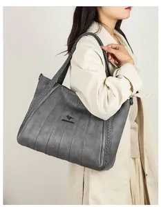 Hoge kwaliteit grote grijze leren shopper tas met kangoeroelogo gedragen door een vrouwelijk model