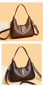 Macro detail of brown embossed hobo handbag with elegant silver metal lock closure
