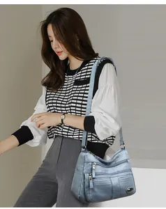 Lifestyle detail of a light blue multi-pocket crossbody bag worn by a female model.
