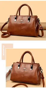 Elegante bolso de mano en cuero marrón con asas trenzadas y detalle de logo canguro