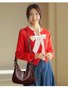 Detailed view of the elegant burgundy embossed underarm shoulder bag worn by a model