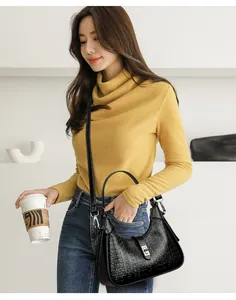 Detailed shot of a black embossed underarm bag carried by a model in lifestyle setting