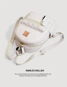 Detailansicht eines cremefarbenen gesteppten PU-Lederrucksacks mit edlem Metall-Logo.