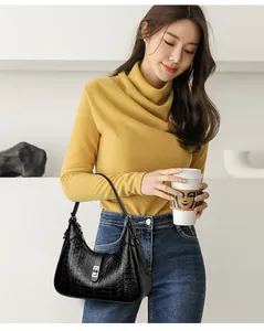 Asian woman holding a black underarm bag with embossed FEINI KAIDI pattern details