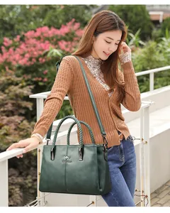 Vista de estilo de vida de bolso de cuero verde oscuro con asas trenzadas y bandolera