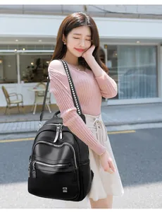 Stylish large capacity black soft leather backpack with patterned strap on model in city