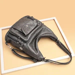 Vintage grey convertible shoulder bag with multiple pockets on a minimalist background
