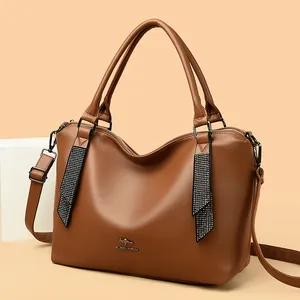 Elegante bolso de mano de piel marrón para mujer con correas decorativas de diamantes