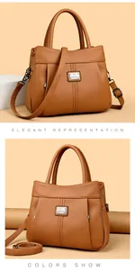 Close-up of a brown pebble leather handbag with elegant metal logo and shoulder strap