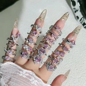 Detalle macro de varios anillos románticos en forma de corazón rosa con circonitas.