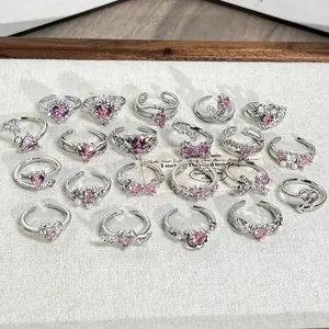 Colección de delicados anillos de plata con circonitas rosas en forma de corazón y lazo.