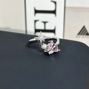 Primer plano de un anillo de plata en forma de corazón con cristal rosa y perla.