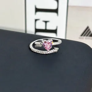 Vista detallada de anillo de corazón en plata con piedra rosa y diseño de flecha