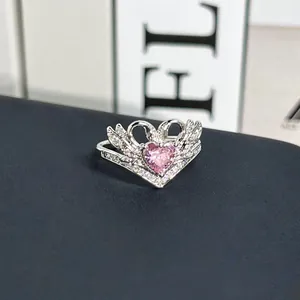 Primer plano de un anillo de cisne plateado con una piedra de circón rosa de corazón