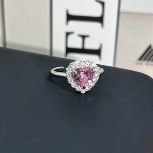 Primer plano detallado de un anillo de cristal rosa en forma de corazón con halo.