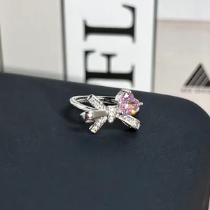 Elegante anillo de plata con una brillante piedra de corazón rosa y diseño de lazo