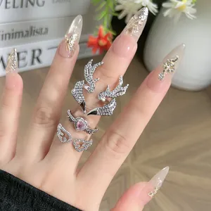 Close-up detail showing silver antler and wing rings with a sparkling heart stone.