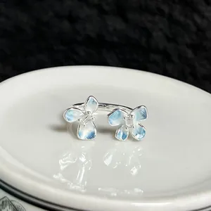 Primer plano de un elegante anillo de flor abierto con pétalos azules degradados.
