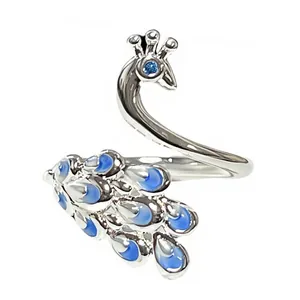 Detalle exquisito de anillo abierto de pavo real plateado con esmalte azul.
