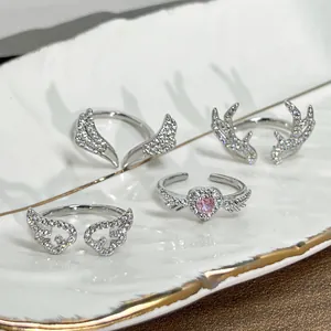 Detailed close-up of silver-tone rings featuring wing and antler motifs with sparkling CZ stones