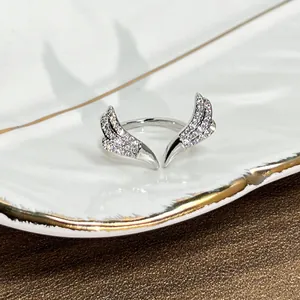 Detailed close-up of a silver wing-shaped open ring with sparkling cubic zirconia