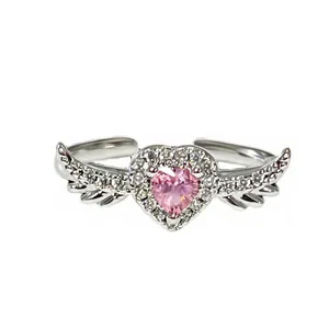 Macro view of adjustable silver ring featuring a pink heart stone and crystal wings