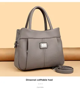 Elegant grey pebbled leather handbag with adjustable strap and vintage metal logo plaque