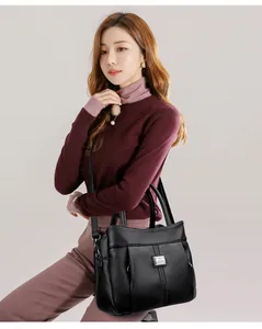 Detailed shot of an elegant black pebbled leather handbag with gold-tone hardware.