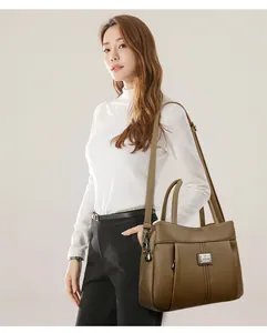 Professional model carrying a stylish vintage brown leather shoulder bag with a logo
