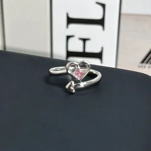 Vista detallada de un anillo de corazón plateado con gemma rosa brillante.