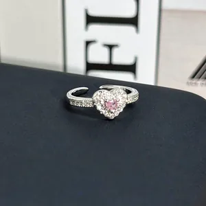 Detalle de un anillo de corazón brillante con piedra rosa y pavé de circonitas en plata.