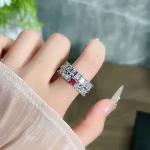 Primo piano di anelli eleganti con pietre a baguette e una gemma rossa a forma di cuore.