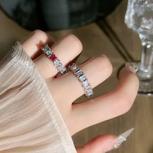 Dettaglio ravvicinato di anello in argento con pietra rossa a cuore e cristalli baguette