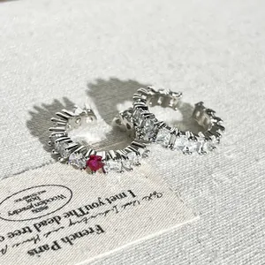 Dettaglio anello aperto a cuore argento con scintillanti zirconi bianchi e rossi.