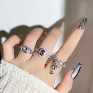 Macro view of silver rings featuring purple zircon stones and intricate floral tassel details