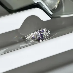 Macro view of oval ring featuring purple and white pavé-set stones on silver band