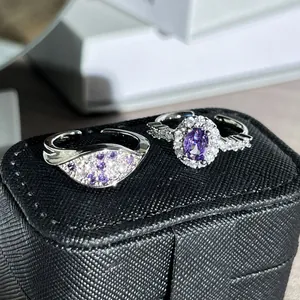 Detail view of silver rings set with sparkling purple and white oval-cut stones.