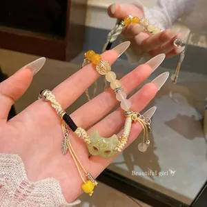 Detailed view of hand-woven retro fox mask pendant with yellow beads and leaf charm.