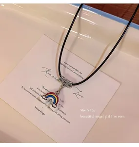 Detailed view of a vibrant rainbow pendant necklace on a black cord with white card