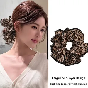 Close-up of a large leopard print scrunchie with a four-layer pleated design.