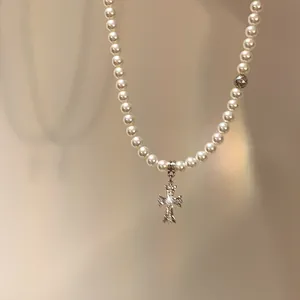 Elegant pearl necklace with a gothic silver-toned cross pendant detail