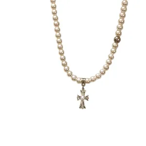 Elegant white pearl necklace featuring a vintage silver-tone gothic floral cross pendant
