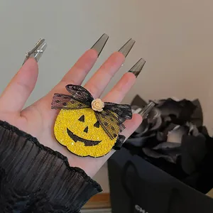 Κοντινό πλάνο κλιπ μαλλιών κολοκύθας Halloween με μαύρο δαντελένιο φιόγκο και ρόδο