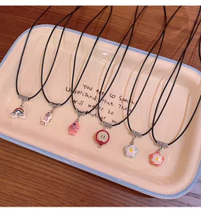 Macro view of colorful dopamine-style necklaces with various cute pendants on a tray