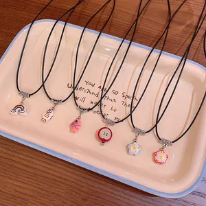 Set of dopamine style colorful flower and rainbow necklaces displayed on a ceramic tray