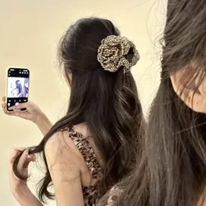 Detailed view of a large leopard print hair claw clip styled on a woman's hair bun