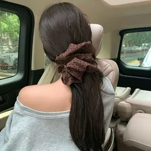 Large vintage leopard print fabric hair accessory shown on a model inside a car