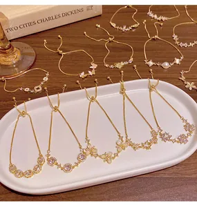 Detailed view of various gold-plated copper bracelets with zircon and cat's eye stones.
