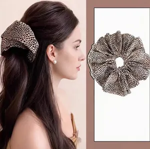 Close-up detail view of a vintage leopard print fabric scrunchie on model and flat lay