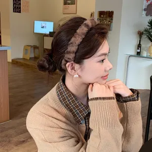 A detailed side view of a model wearing a soft plush brown leopard print headband